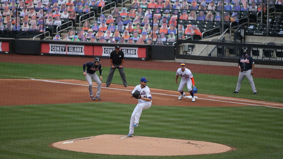 PHOTO: New York Mets starting pitcher Jacob deGrom pitches as Atlanta Braves first baseman Freddie Freeman takes a lead against Mets first baseman Pete Alonso during the first inning of an opening day game at Citi Field, July 24, 2020, in New York.
