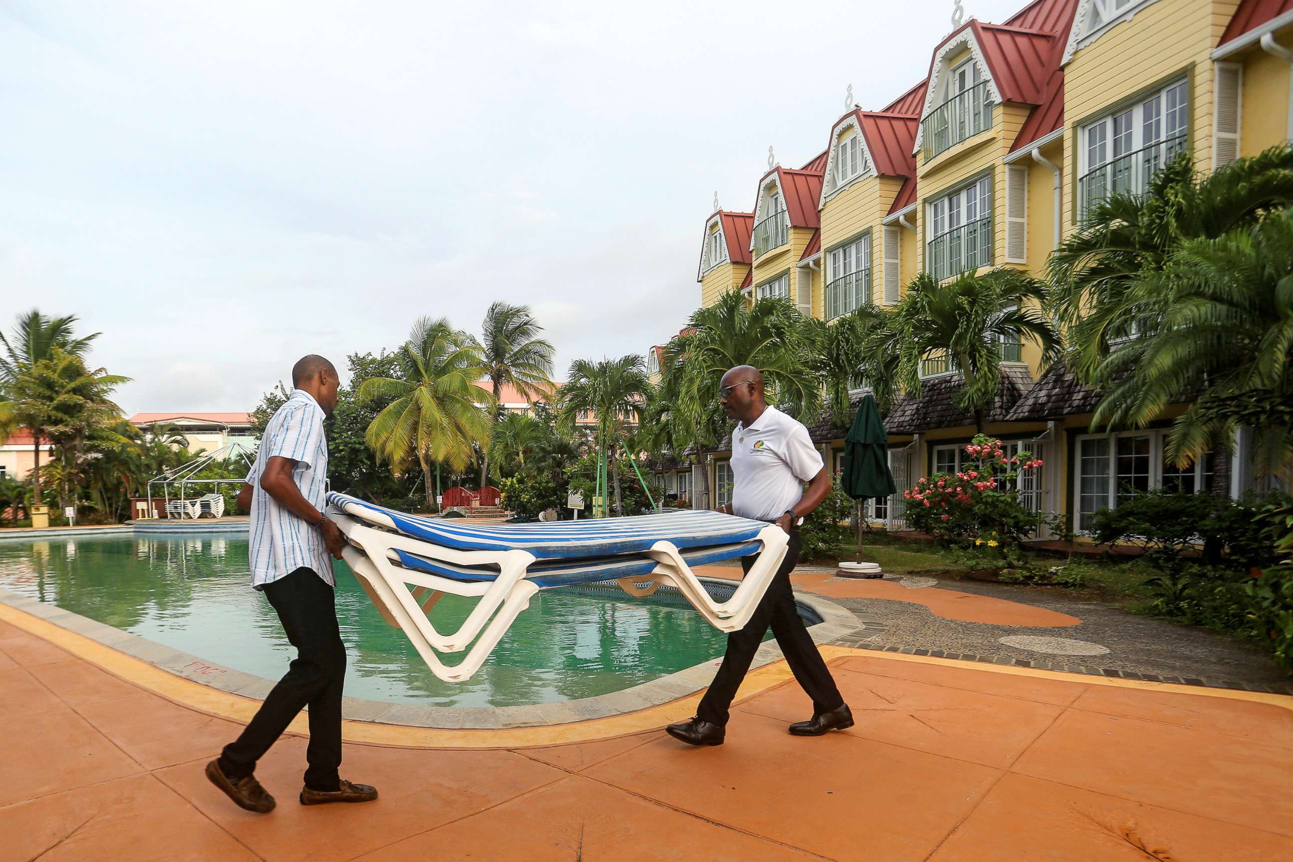 PHOTO: Hotel employees remove beach cots from the pool area in preparation for the arrival of Tropical Storm Dorian in Gros Islet, St. Lucia, Aug. 26, 2019.
