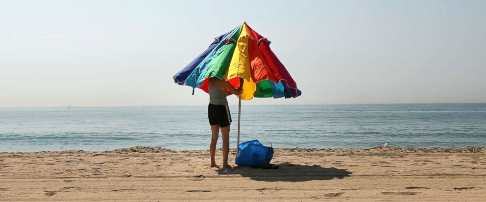4 Tips For Keeping Your Beach Umbrella Secure This Summer Abc News Photo A Woman Closes Her Beach Umbrella Before Leaving The Near Los Angeles