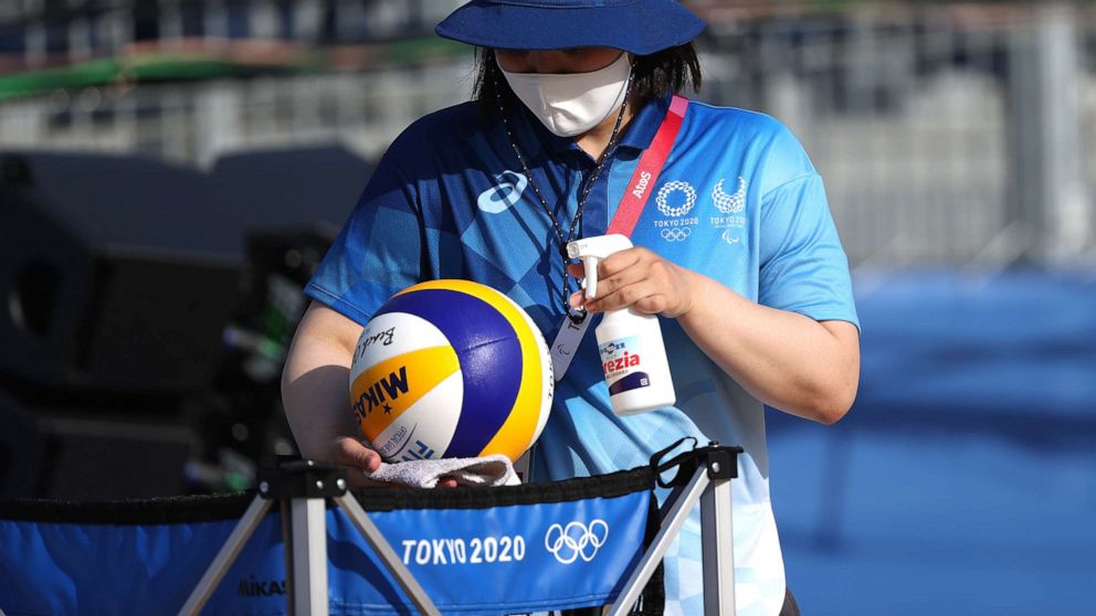 PHOTO: A worker sanitizes beach volleyballs during training at Shiokaze Park ahead of the Tokyo 2020 Olympic Games on July 20, 2021, in Tokyo.