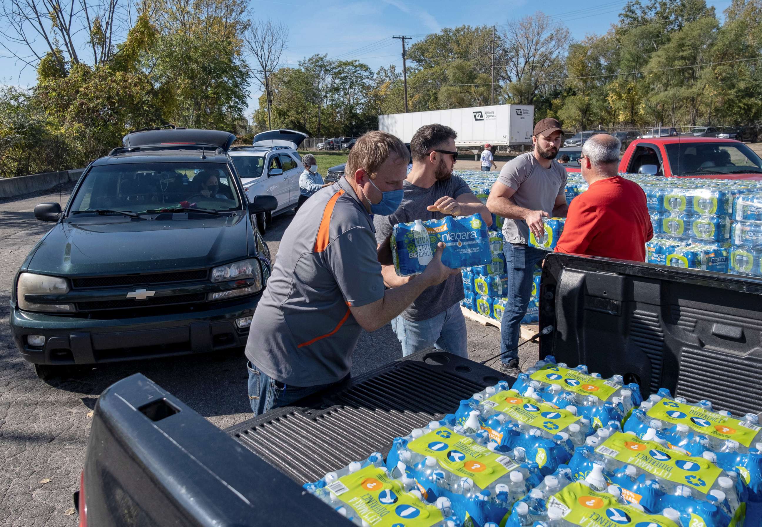 PHOTO: Volunteers with Southwest Community Action Agency load cases of bottled water into residents vehicles, as city officials warn of dangerous amounts of lead in the city's water systems, in Benton Harbor, Mich., Oct. 20, 2021.