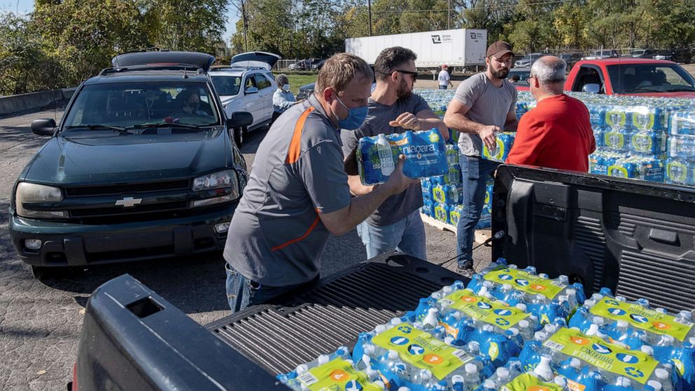 PHOTO: Volunteers with Southwest Community Action Agency load cases of bottled water into residents vehicles, as city officials warn of dangerous amounts of lead in the city's water systems, in Benton Harbor, Mich., Oct. 20, 2021.