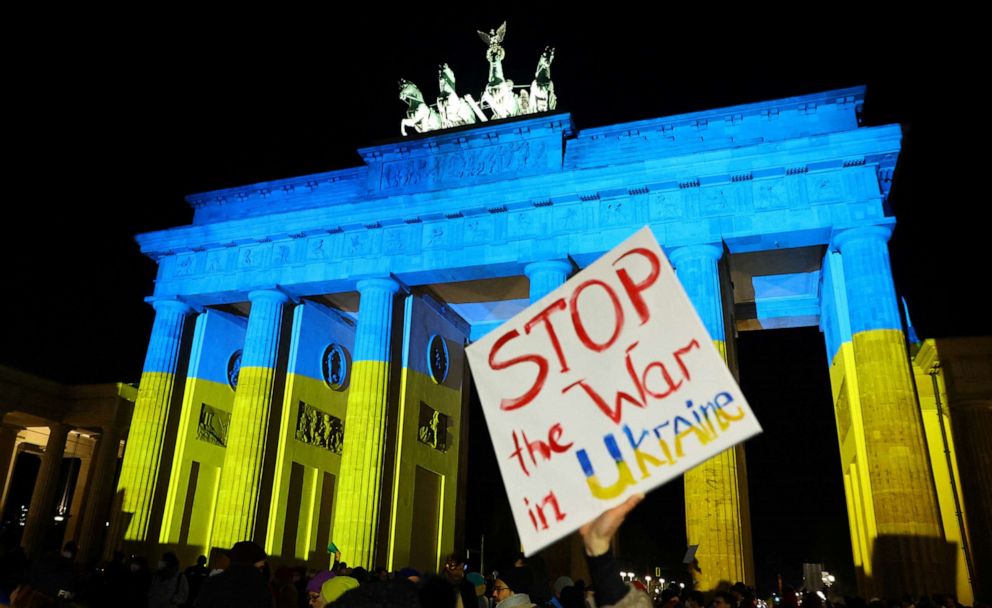 PHOTO: A banner is pictured in front of Brandenburg Gate lit up in the colours of Ukrainian flag during an anti-war protest in Berlin, Feb. 24, 2022.