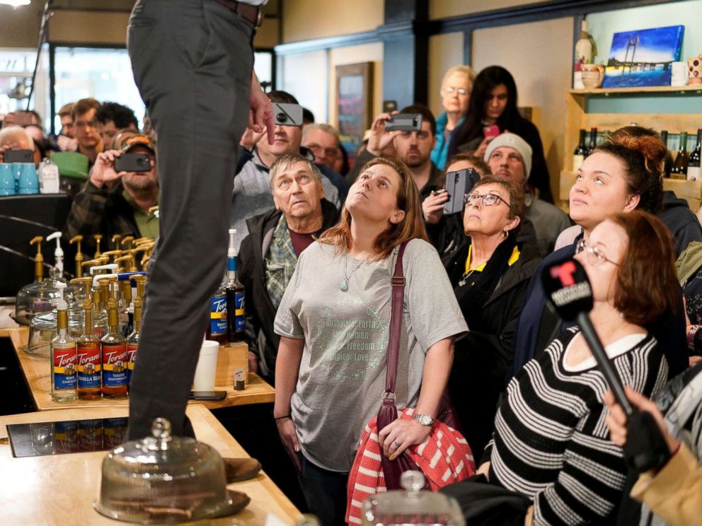 PHOTO: Attendees listen as Democratic 2020 presidential candidate Beto ORourke, standing on counter, speaks during a campaign stop at a coffee house in Burlington, Iowa, March 14, 2019.