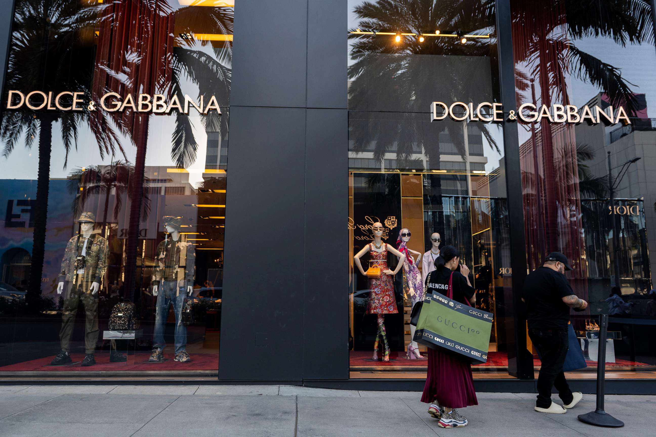 PHOTO: People carrying shopping bags wait in line outside the Dolce & Gabbana store on Rodeo Drive in Beverly Hills, Feb. 4, 2022, in Los Angeles.