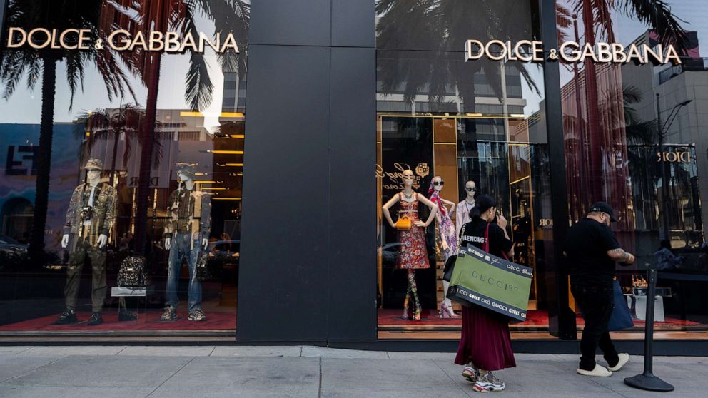 PHOTO: People carrying shopping bags wait in line outside the Dolce & Gabbana store on Rodeo Drive in Beverly Hills, Feb. 4, 2022, in Los Angeles.