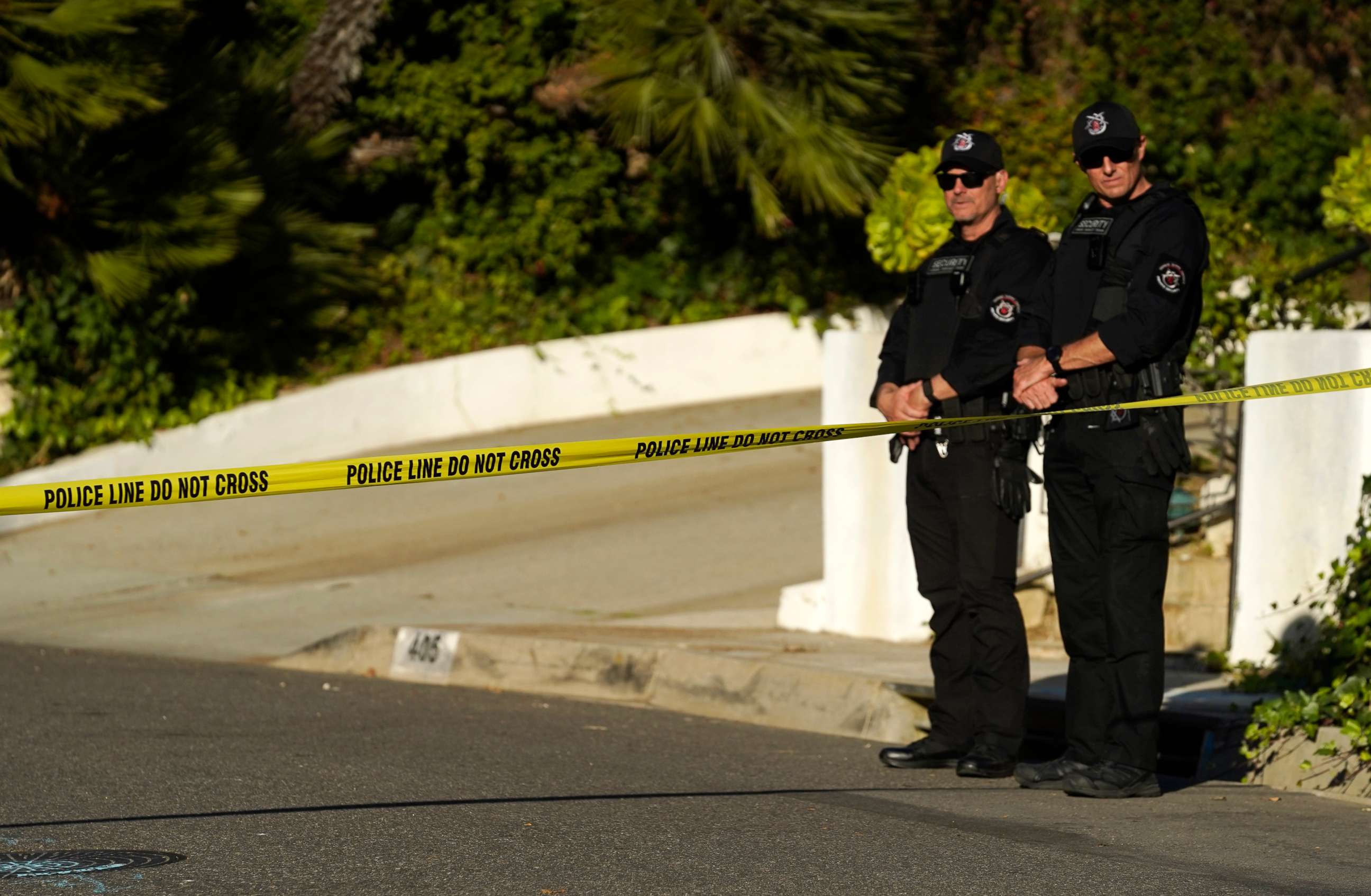 PHOTO: Security guards patrol behind police tape set up at the intersection of Maytor Place and Barrie Drive in the Trousdale Estates section of Beverly Hills, Calif., Dec. 1, 2021.