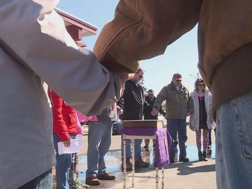 PHOTO: Congregants of the Springs United Methodist Church in Plover, Wisconsin, pray around a Bible that survived a fire that destroyed the church.