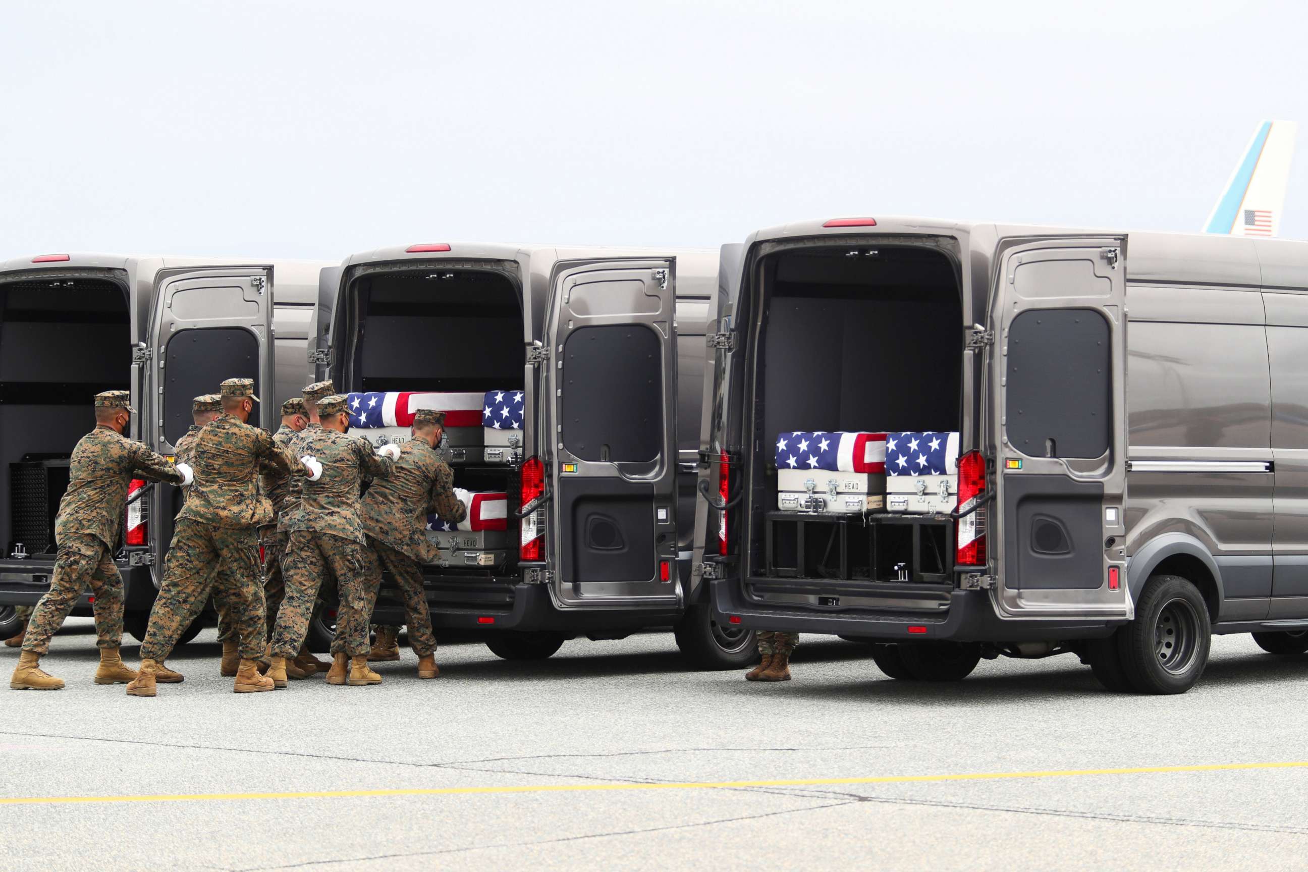 PHOTO: Members of the armed forces place one of the transfer cases containing the remains of U.S. Military service members who were killed by a suicide bombing at the Hamid Karzai International Airport, at Dover Air Force Base in Dover, Aug. 29, 2021.