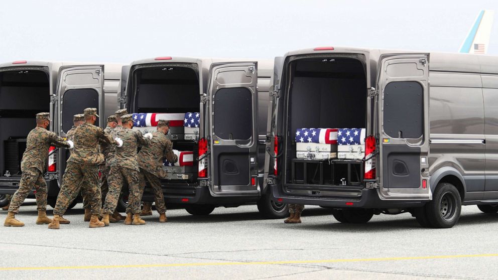 PHOTO: Members of the armed forces place one of the transfer cases containing the remains of U.S. Military service members who were killed by a suicide bombing at the Hamid Karzai International Airport, at Dover Air Force Base in Dover, Aug. 29, 2021.
