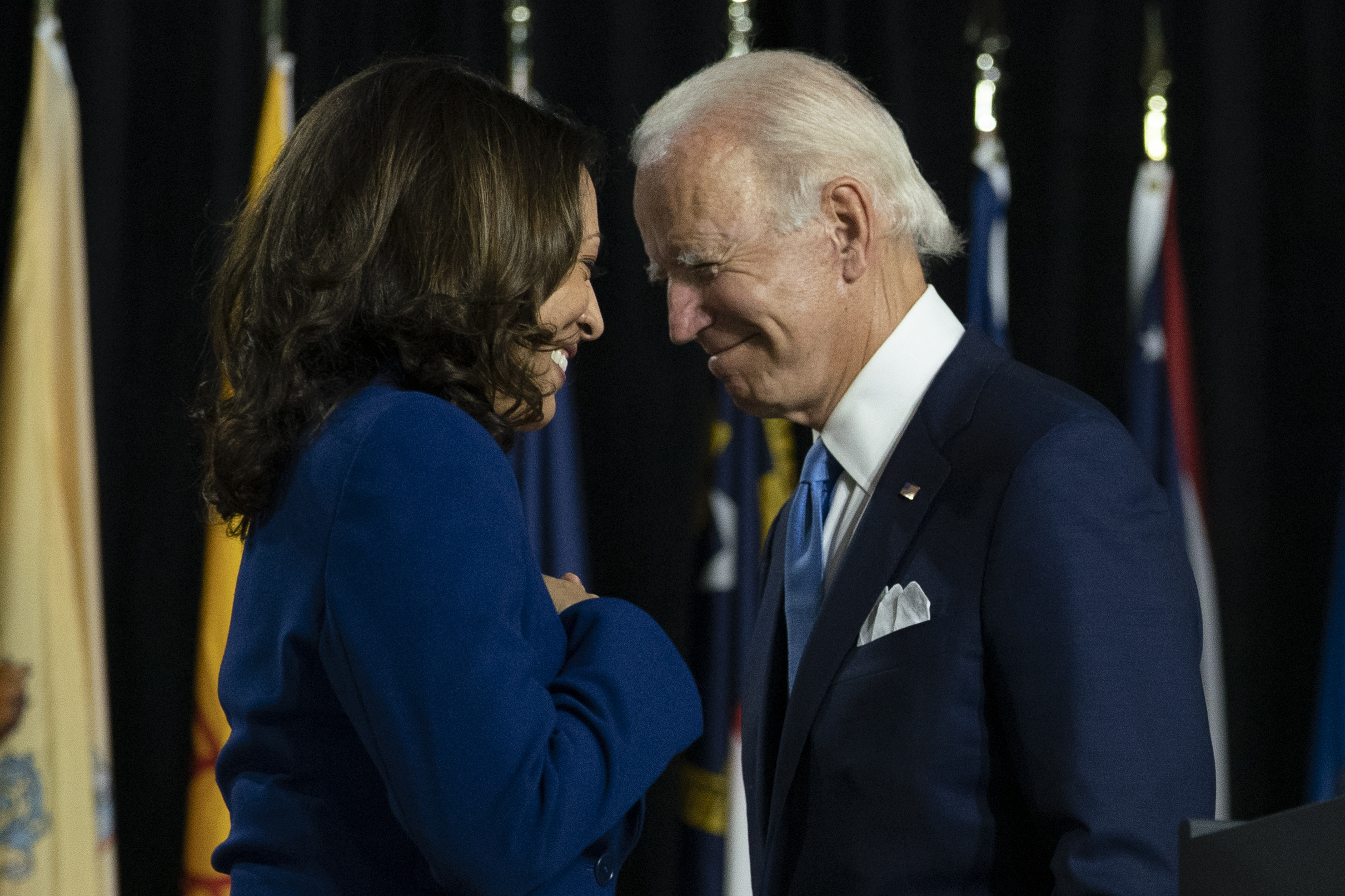 PHOTO: Former Vice President Joe Biden and his running mate Sen. Kamala Harris, D-Calif., pass each other as Harris moves to the podium to speak during a campaign event at Alexis Dupont High School in Wilmington, Del., Wednesday, Aug. 12, 2020.