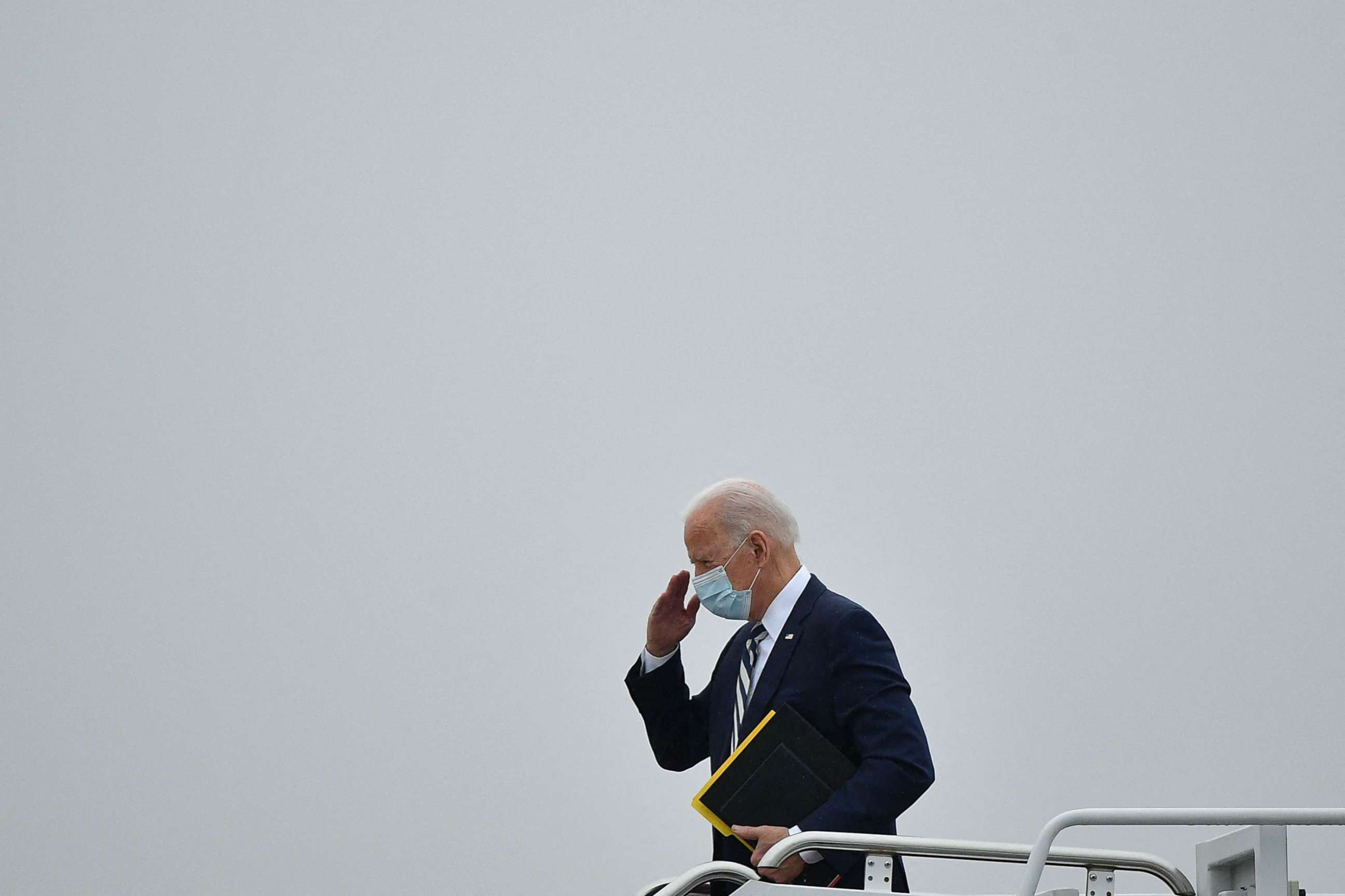 PHOTO: US President Joe Biden salutes before he boards Air Force One departing from New Castle Airport in New Castle, Delaware on March 1, 2021. - Biden is returning to Washington after spending the weekend at his Wilmington home. 