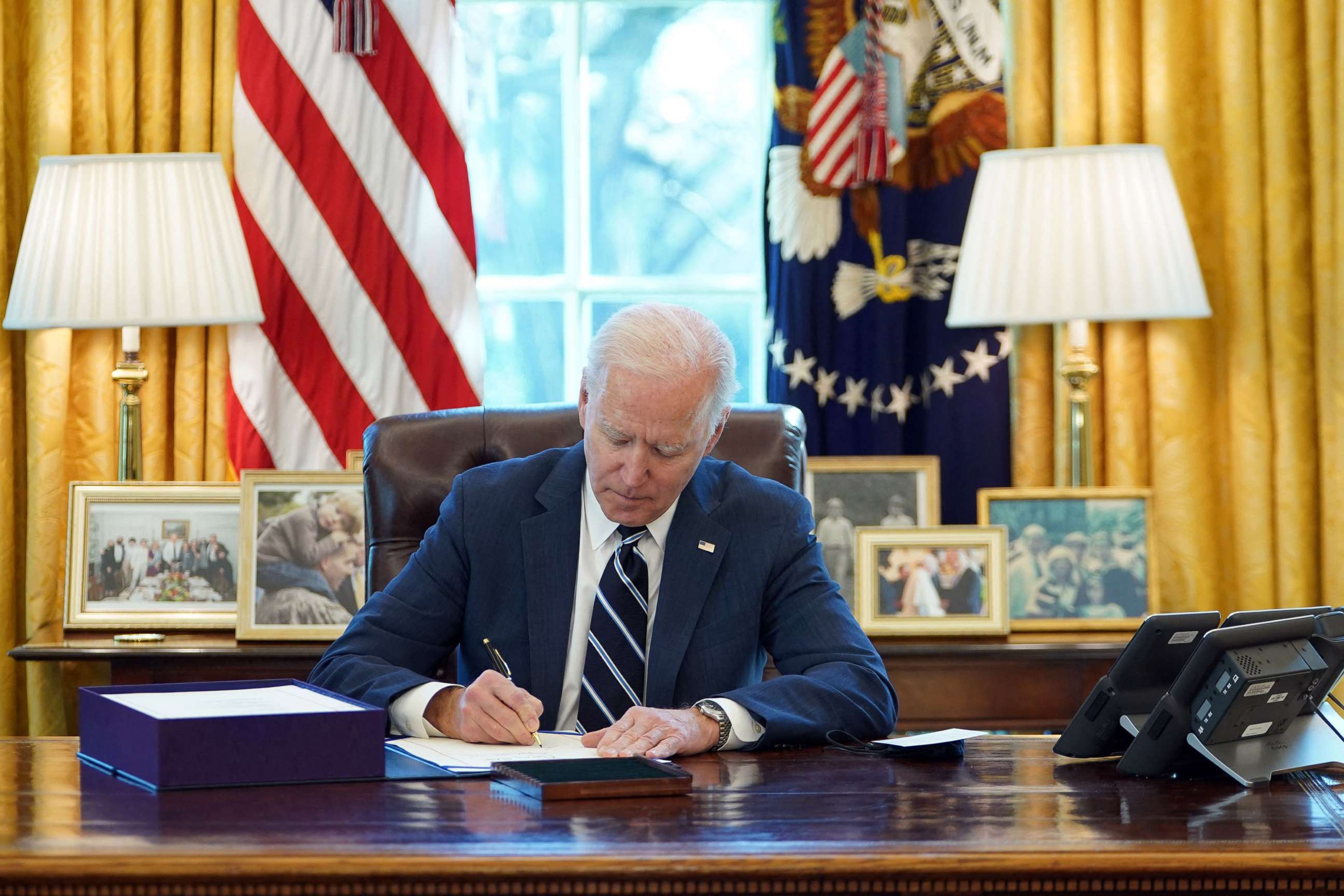 PHOTO: President Joe Biden signs the American Rescue Plan on March 11, 2021, in the Oval Office of the White House in Washington, D.C.  
