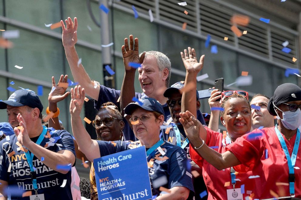 PHOTO: New York Mayor Bill De Blasio waves during a "Hometown Heroes ticker tape parade" honoring frontline workers of the COVID-19 pandemic, in Manhattan, New York, July 7, 2021. 