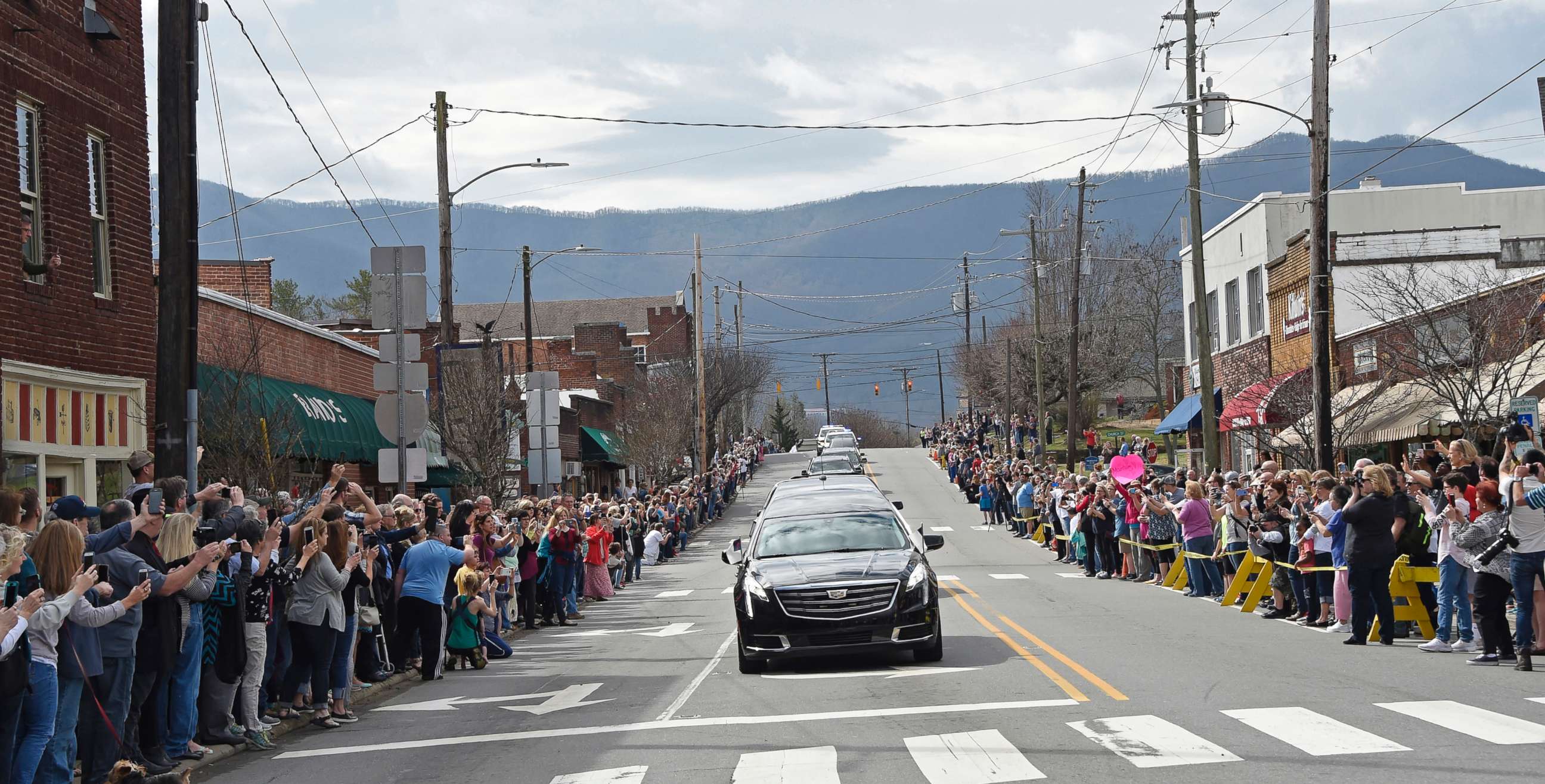 PHOTO: People line the street to pay respects as the hearse carrying the body of Rev. Billy Graham travels through Black Mountain, N.C., Feb. 24, 2018.