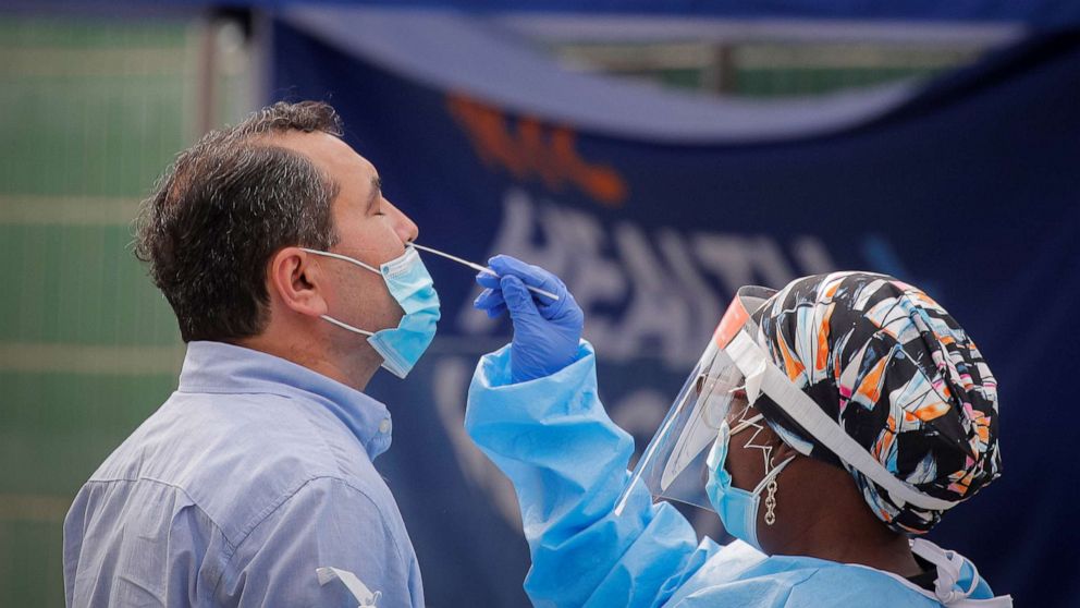 PHOTO: A health worker takes a swab sample from a man to test for the coronavirus disease in the Borough Park area of Brooklyn, N.Y., Sept., 25, 2020.