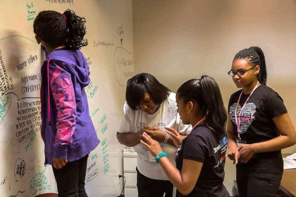 PHOTO: Alumna Azure Butler (right) and other participants are seen engaging in an activity alongside Black Girls CODE leadership in the program's earlier days of the Bay Area chapter in California.