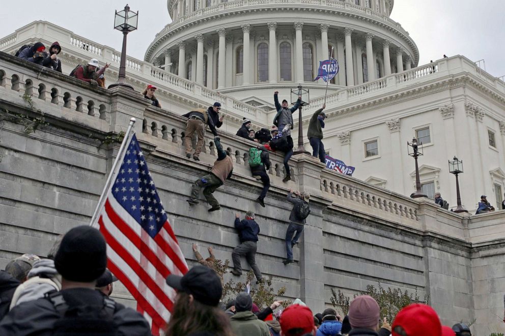 PHOTO: Supporters of U.S. President Donald Trump climb a wall during a protest against the certification of the 2020 presidential election results by the Congress, at the Capitol in Washington, Jan. 6, 2021.