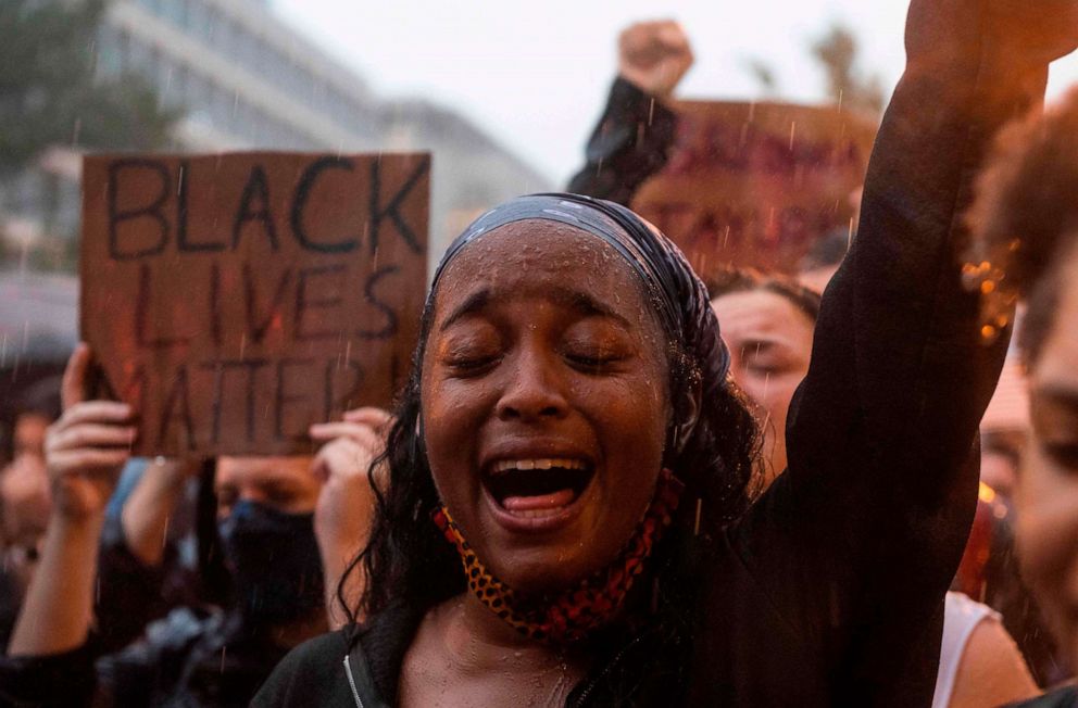 PHOTO: A protester shouts "Black Lives Matter" during a rain storm in front of Lafayette Park next to the White House, Washington, DC, June 5, 2020.