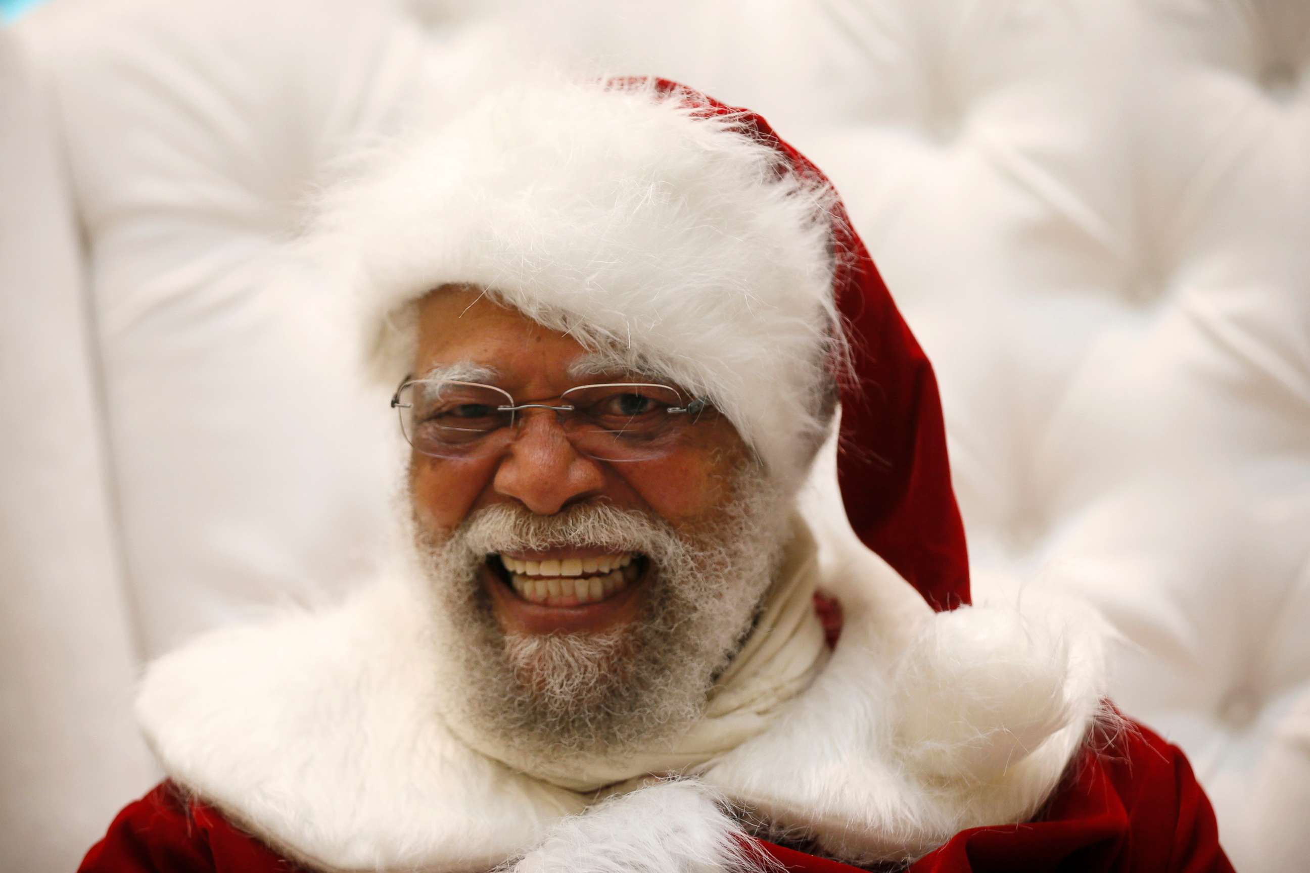PHOTO: In this Dec. 16, 2013, file photo. Santa Claus Langston Patterson, 77, laughs as he greets children at Baldwin Hills Crenshaw Plaza mall in Los Angeles.