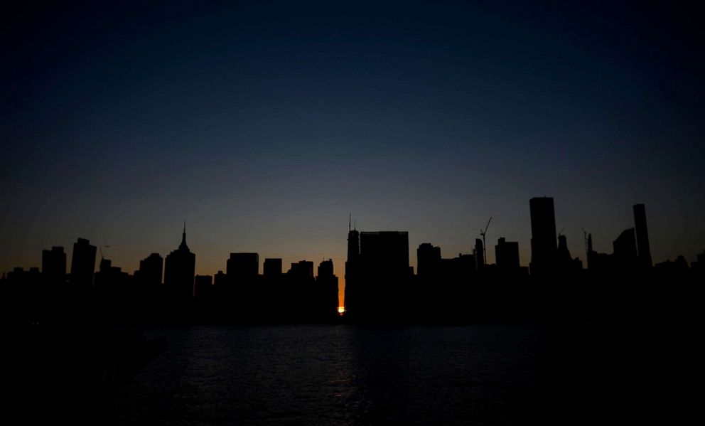 PHOTO: The sun sets behind 42nd Street in Manhattan during a power outage in New York, July 13, 2019. 