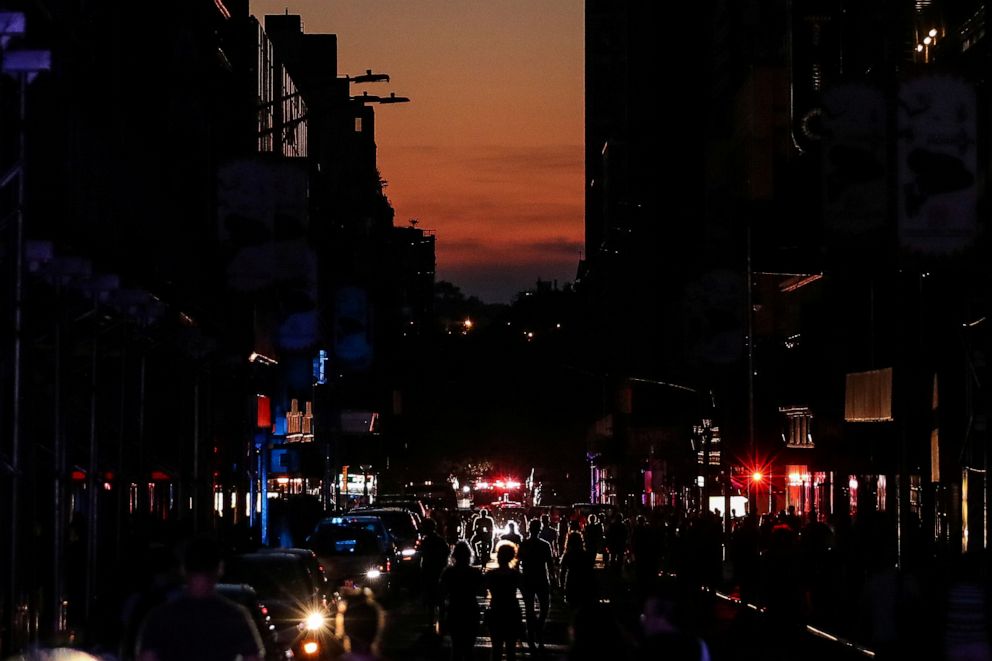 PHOTO: People walk along a dark street near Times Square during a blackout in New York, July 13, 2019. 