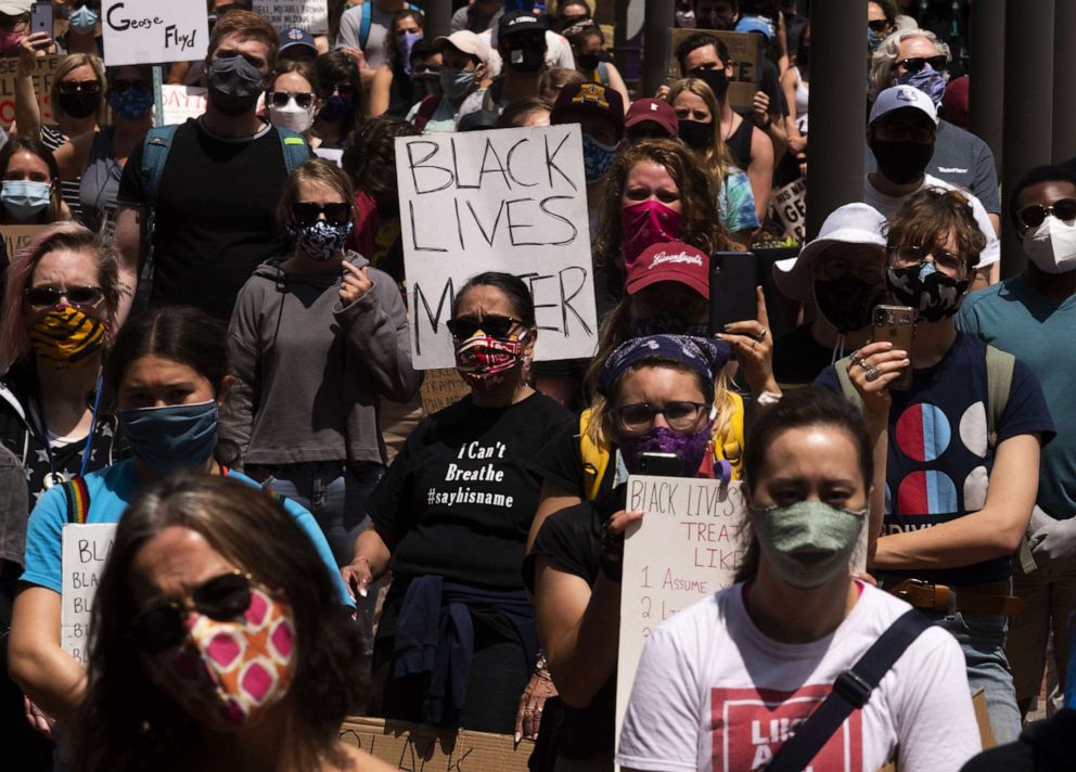 PHOTO: People hold signs during a demonstration outside the Hennepin County Government Center, on June 13, 2020, in Minneapolis.