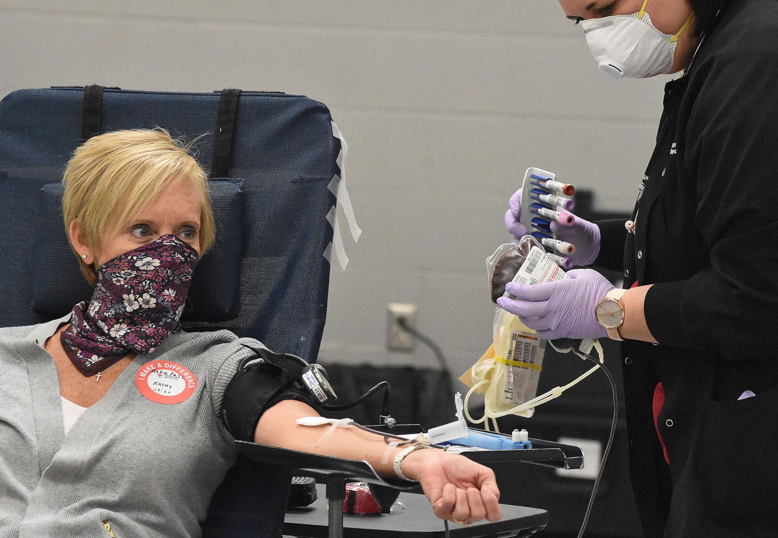 PHOTO: Wearing a homemade mask, Kathy Verhoff of Kalida, Ohio, donates blood as phlebotomist Jacqueline Line looks on at the American Red Cross in Lima, Ohio, on April 7, 2020.