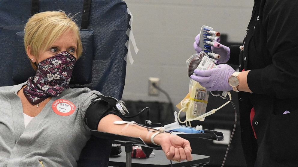 PHOTO: Wearing a homemade mask, Kathy Verhoff of Kalida, Ohio, donates blood as phlebotomist Jacqueline Line looks on at the American Red Cross in Lima, Ohio, on April 7, 2020.