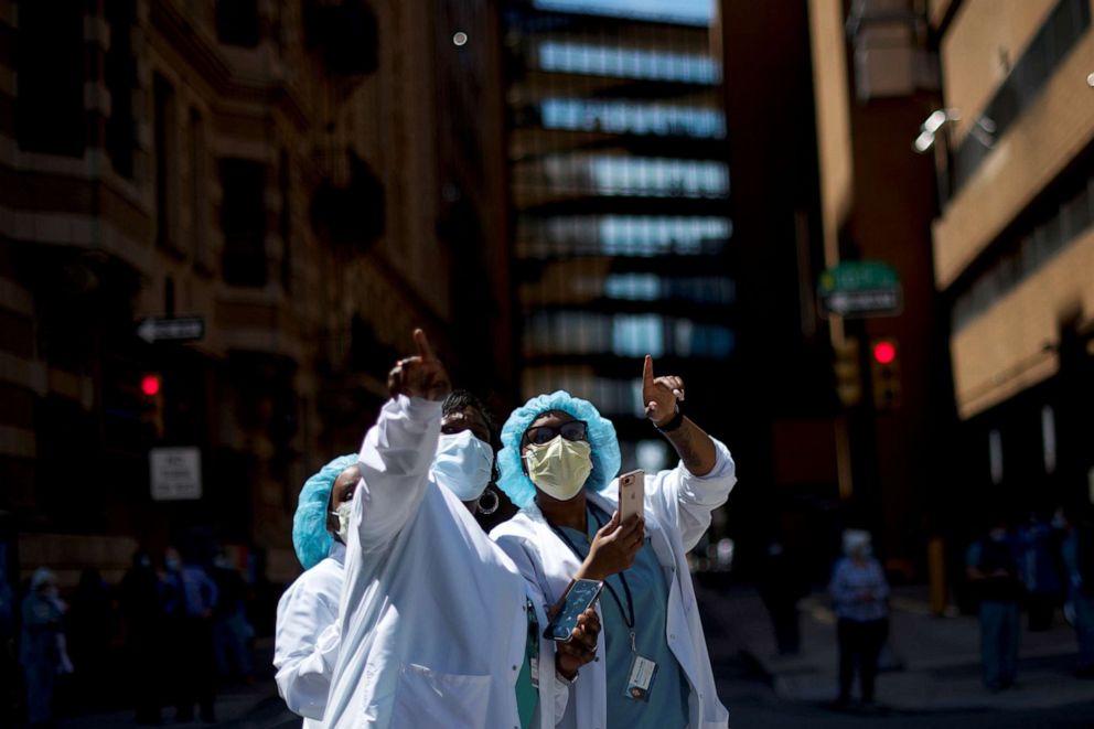 PHOTO: Healthcare workers react as they watch a flyover by the U.S. Navy Blue Angels and U.S. Air Force Thunderbirds demonstration teams as a salute to first responders and essential workers during the outbreak of the coronavirus in Philadelphia.  