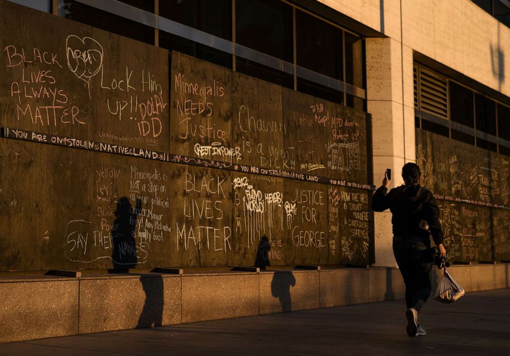 PHOTO: Messages written in chalk adorn the boarded windows across the street from the Hennepin County Government Center, March 9, 2021, in Minneapolis, as jury selection continues in the trial of former Minneapolis Police officer Derek Chauvin.