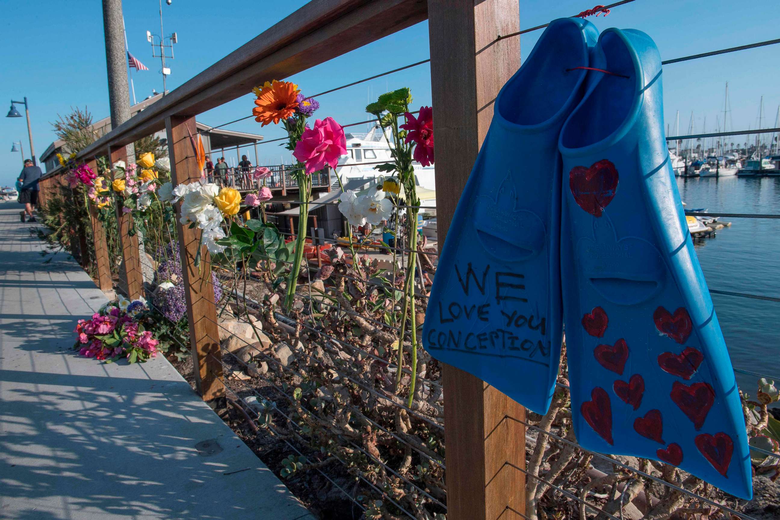 PHOTO: A pair of diving fins and flowers at a memorial wall near the Truth Aquatics moorings where the boat that burned and sank off the Santa Cruz islands, was based in Santa Barbara, Calif., on Sept. 2, 2019.