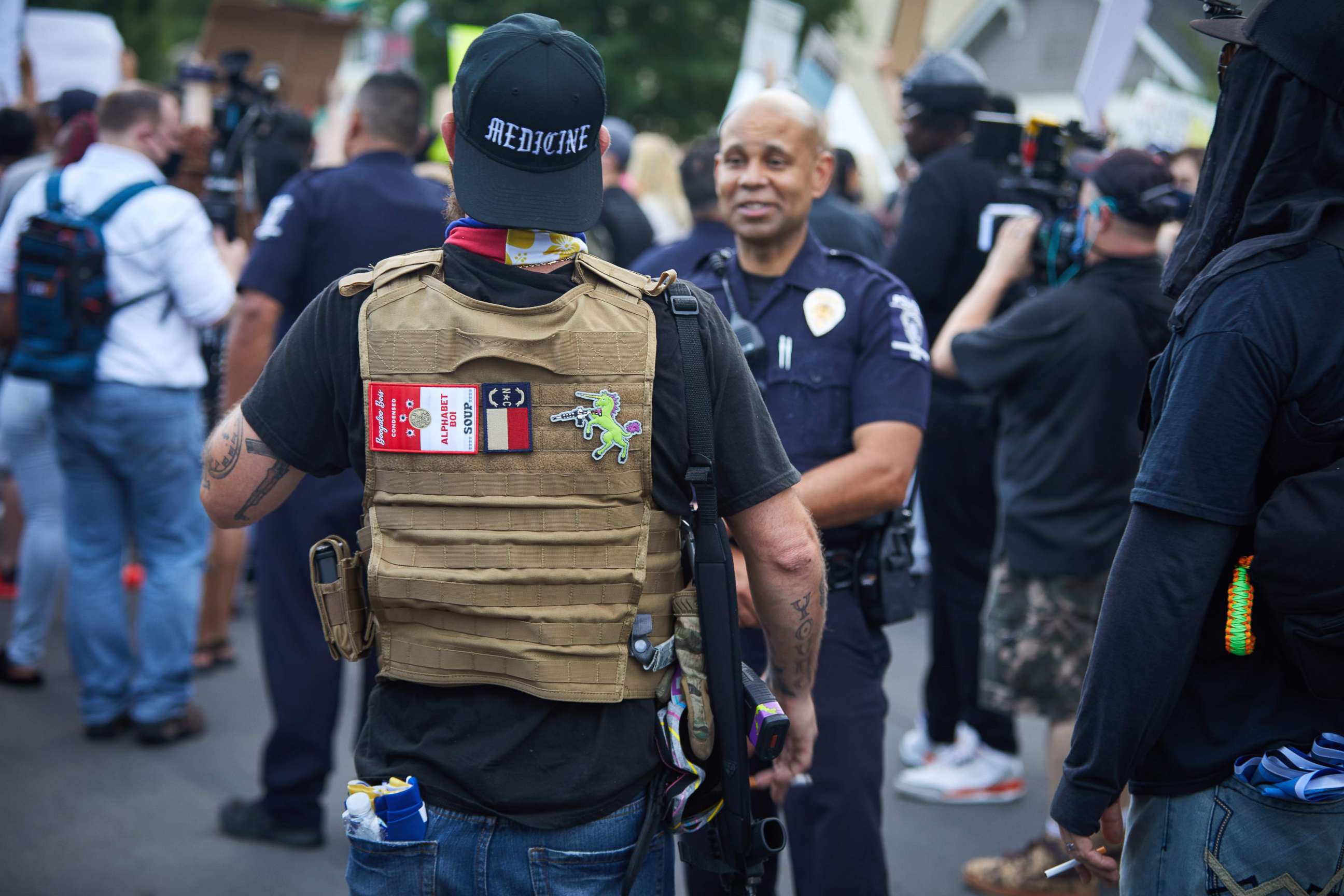 PHOTO: A member of the far-right militia, Boogaloo Bois, walks next to protestors demonstrating outside Charlotte Mecklenburg Police Department Metro Division 2 just outside of downtown Charlotte, North Carolina, on May 29, 2020. 