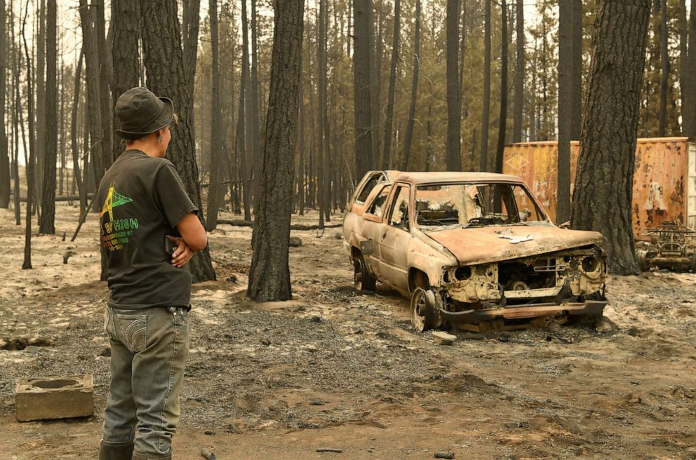 PHOTO: Pam Brown observes a burnt out truck on her friend's property after it was destroyed by the Bootleg Fire, in Sycan Estates, Ore., July 24, 2021.
