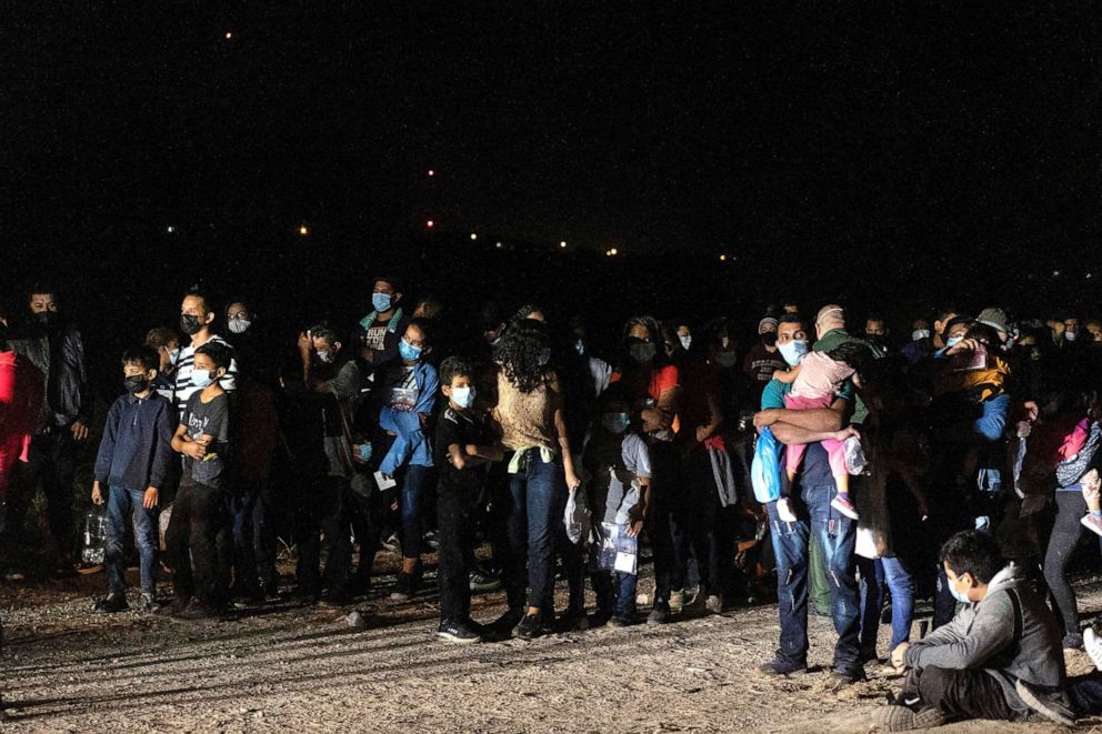 PHOTO: Asylum-seeking migrant families from Central America wait to be processed by the U.S. Border Patrol agents after crossing the Rio Grande river into the United States from Mexico in Roma, Texas, July 30, 2021.