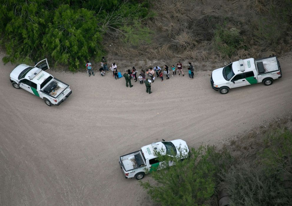 PHOTO: US Border Patrol agents take asylum seekers into custody near the US-Mexico Border on March 23, 2021, in McAllen, Texas.