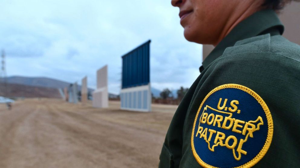 A U.S. Border Patrol officer stands near prototypes of US President Donald Trump's proposed border wall, Nov. 1, 2017, in San Diego, Calif.
