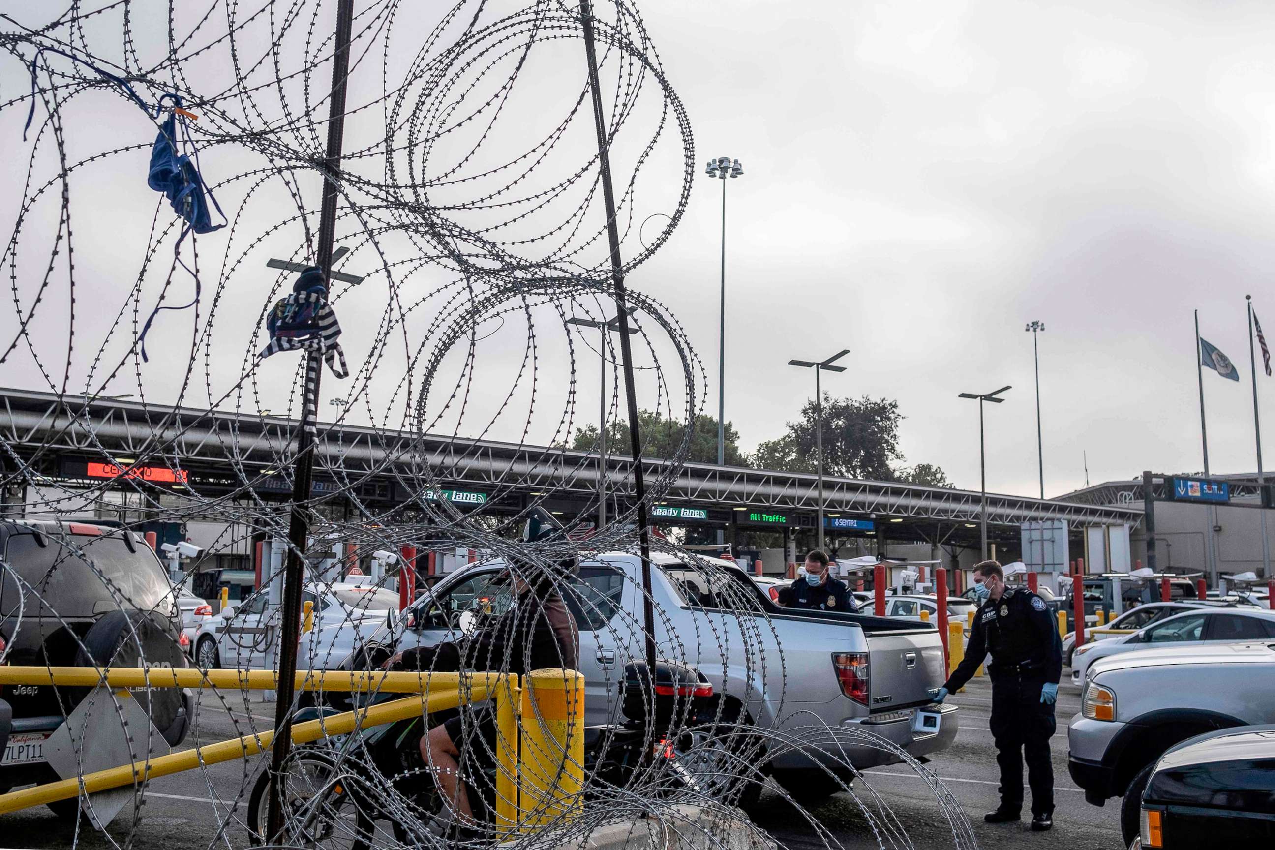 PHOTO: Customs and Border Protection agents check a vehicle as commuters queue to cross Mexican border towards the US at the Otay commercial crossing port in Tijuana, Baja California state, Mexico, July 7, 2020. 