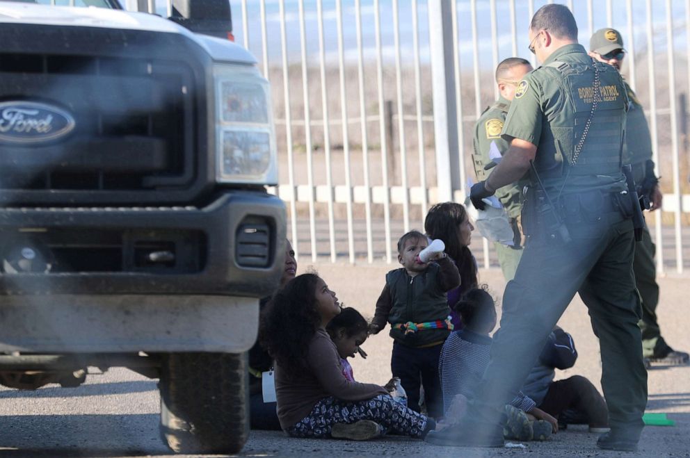 PHOTO: In this Dec. 7, 2018, file photo, U.S. Customs and Border Protection (CBP) officials detain a migrant woman and children after they crossed illegally with other migrants from Mexico to the U.S.