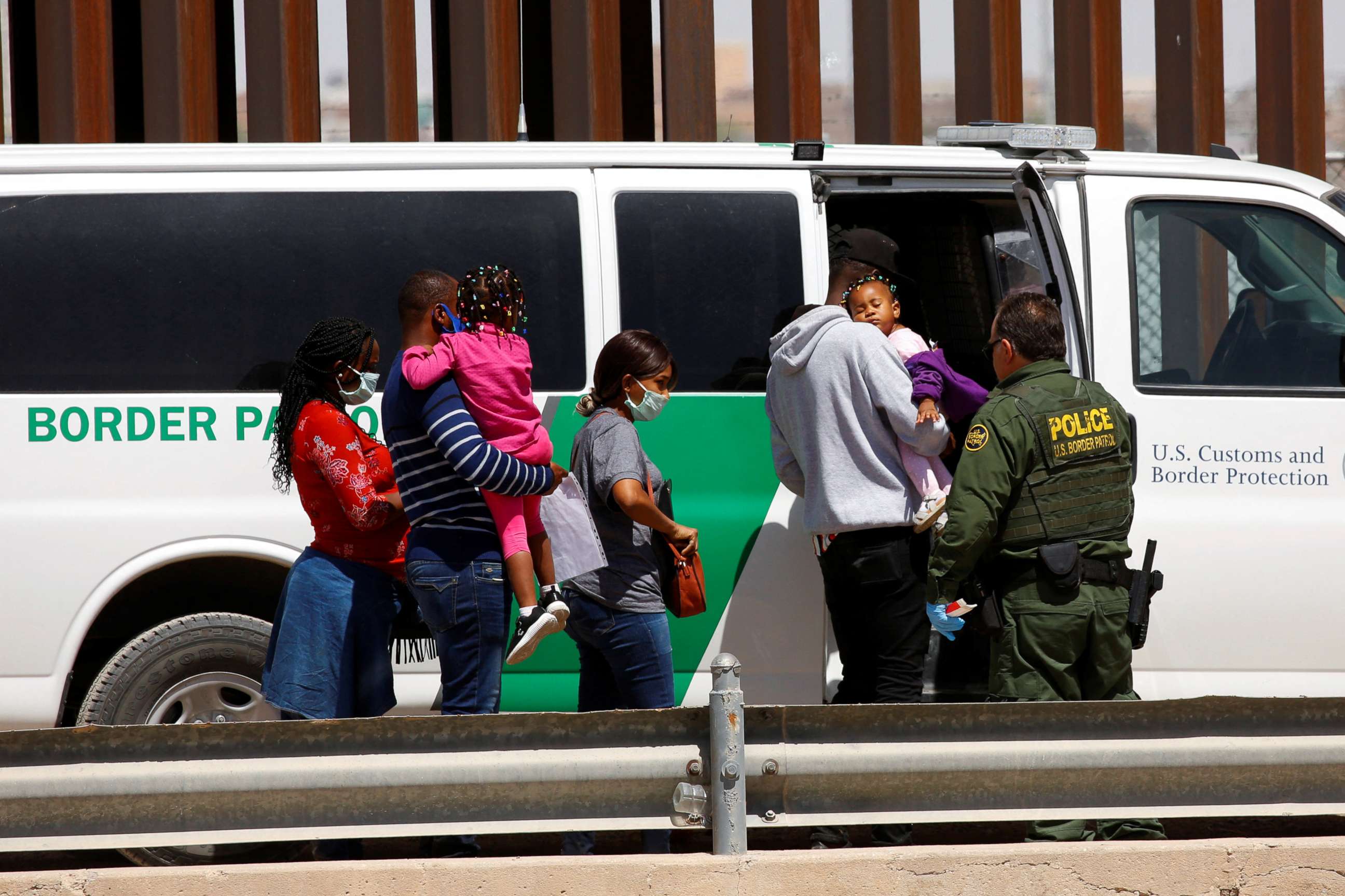 PHOTO: Asylum-seeking migrants are taken to a van by a U.S. Border Patrol agent after they crossed the Rio Bravo, in El Paso, Texas, as seen from Ciudad Juarez, Mexico, April 6, 2022.