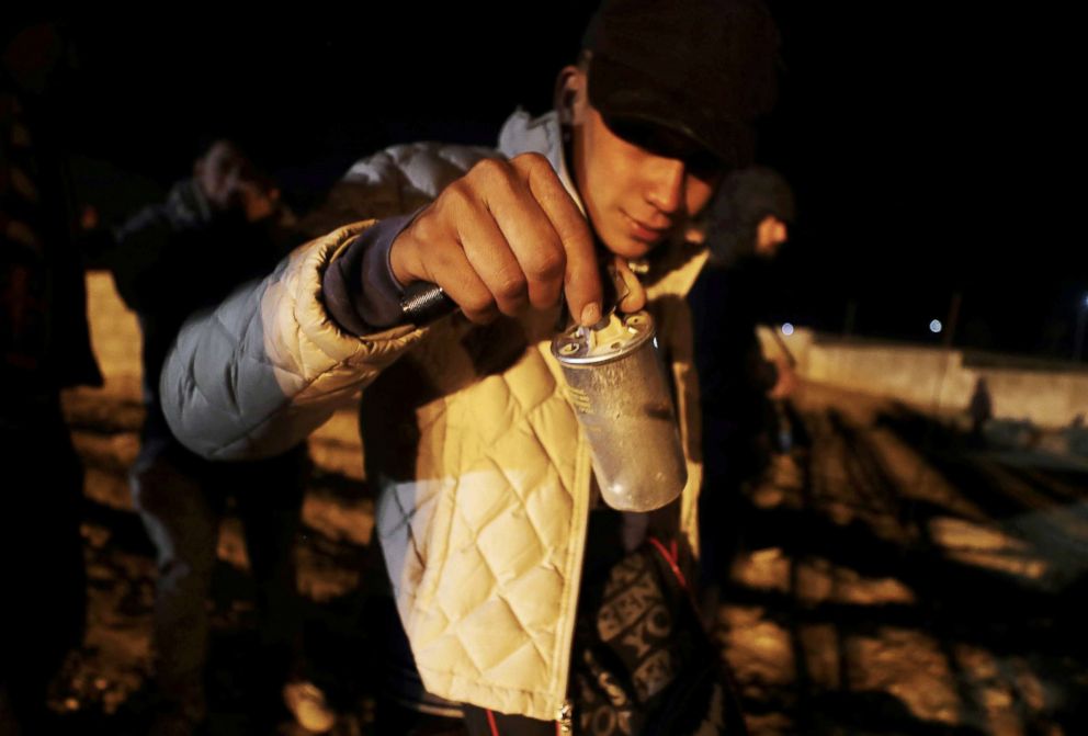 PHOTO: A migrant holds a tear gas canister after U.S. Customs and Border Protection officials threw it to the Mexican side of the fence as migrants prepare to cross it illegally, in Tijuana, Mexico, Jan. 1, 2019.