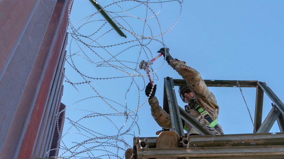 PHOTO: A Soldier with the 515th Sapper Company, 5th Engineer Battalion, 36th Engineer Brigade, cuts off loose strands of concertina wire along the border infrastructure near the DeConcini Port of Entry, Dec. 19, 2018, in Nogales, Arizona.