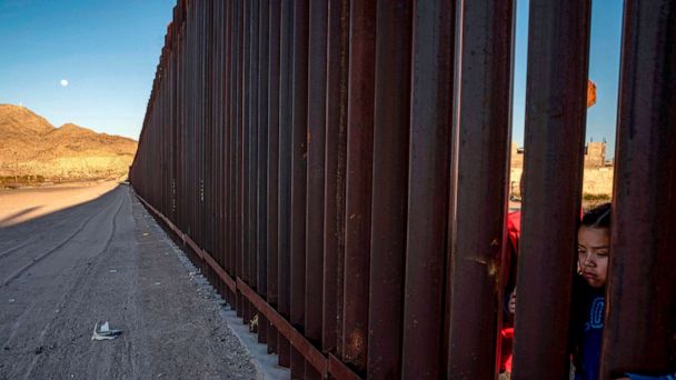 PHOTO: A young girl holds onto the metal fencing on the US-Mexico border in Anapra, New Mexico, March 19, 2019.