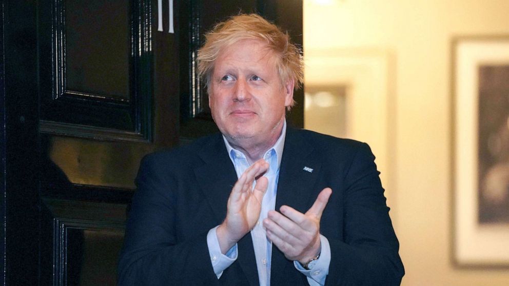 PHOTO: Britain's Prime Minister Boris Johnson claps outside 11 Downing Street to salute local heroes during Thursday's nationwide Clap for Carers NHS initiative to applaud workers fighting the coronavirus pandemic, in London, Thursday, April 2, 2020. 