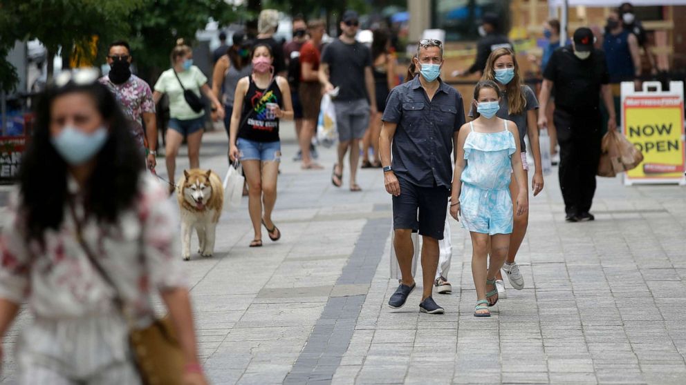 PHOTO: Pedestrians wear masks out of concern for the coronavirus, June 28, 2020, while walking along a sidewalk, in Boston.