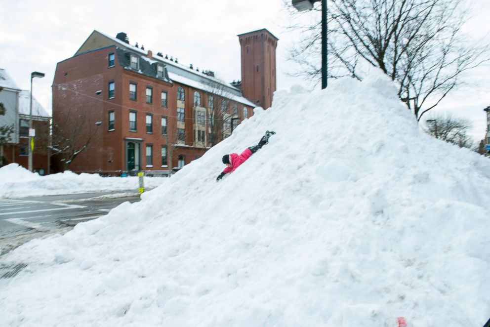 PHOTO: A child slides down a 20 foot pile of snow after the Blizzard of 2015 in the South End of Boston, Mass. on Jan. 27, 2015,