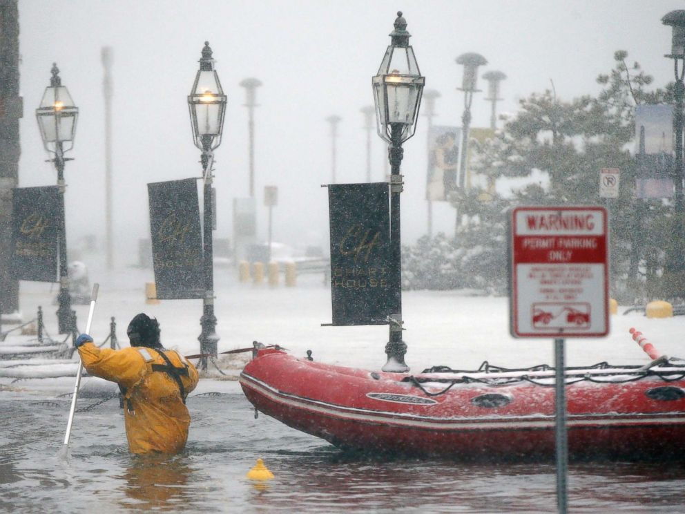 FOTO: Um bombeiro vagueia pelas águas da enchente do Porto de Boston em Long Wharf em Boston, em 4 de janeiro de 2018. 