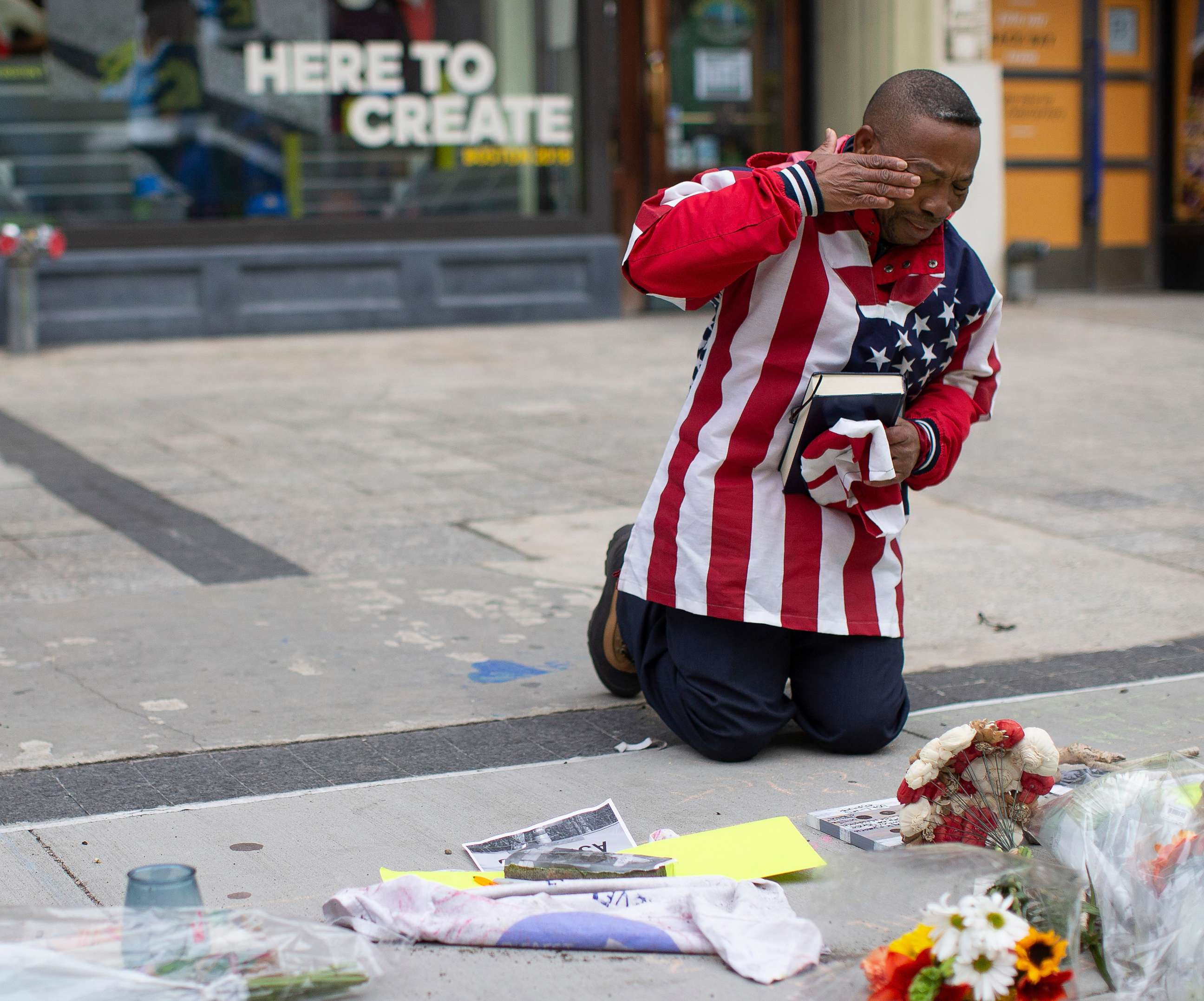 Christopher Nzenwa wipes tears away after praying at a memorial outside of Marathon Sports at the location of the first explosion, during a memorial ceremony on the fifth anniversary of the Boston Marathon Bombing in Boston, April 15, 2018.