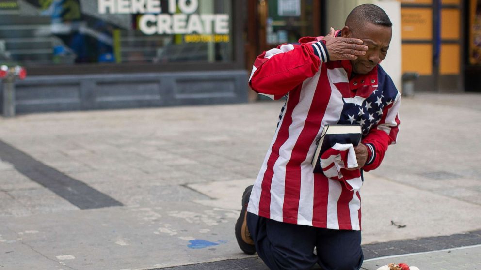 Christopher Nzenwa wipes tears away after praying at a memorial outside of Marathon Sports at the location of the first explosion, during a memorial ceremony on the fifth anniversary of the Boston Marathon Bombing in Boston, April 15, 2018.