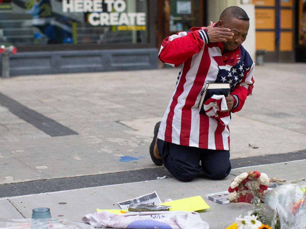 Christopher Nzenwa wipes tears away after praying at a memorial outside of Marathon Sports at the location of the first explosion, during a memorial ceremony on the fifth anniversary of the Boston Marathon Bombing in Boston, April 15, 2018.